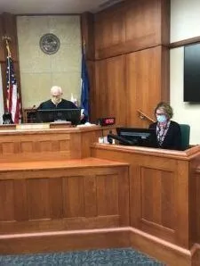 A Judge and a Court Reporter sitting at the bench in a courtroom.