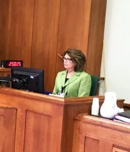 Digital Court Reporter sitting at the bench taking notes in a courtroom.