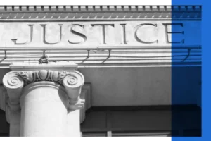 Black and white image of a courthouse exterior displaying the word 'justice'