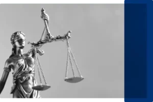 A black and white image of a lady justice statue carrying the scales.