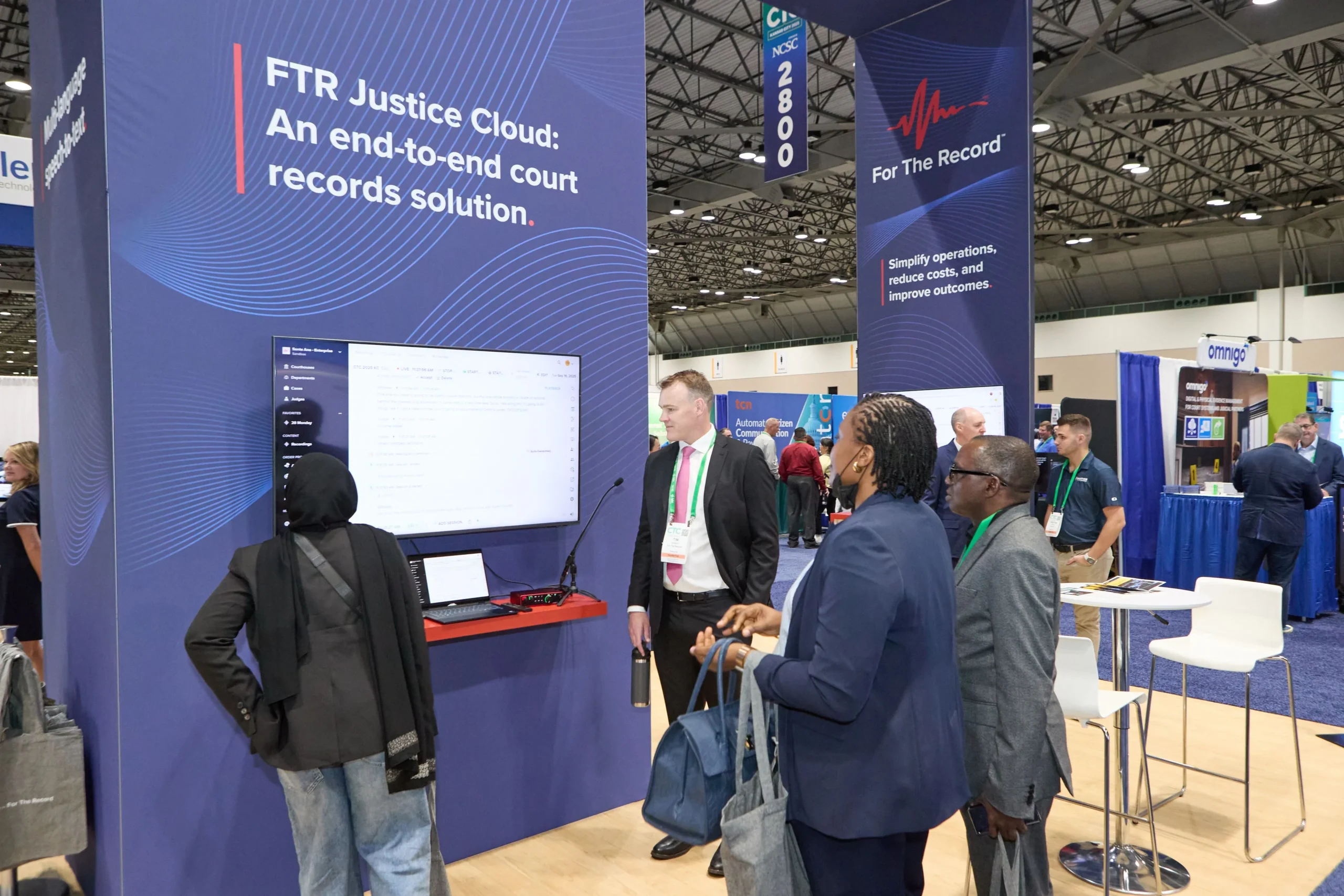 People receiving a demonstration at the conference booth