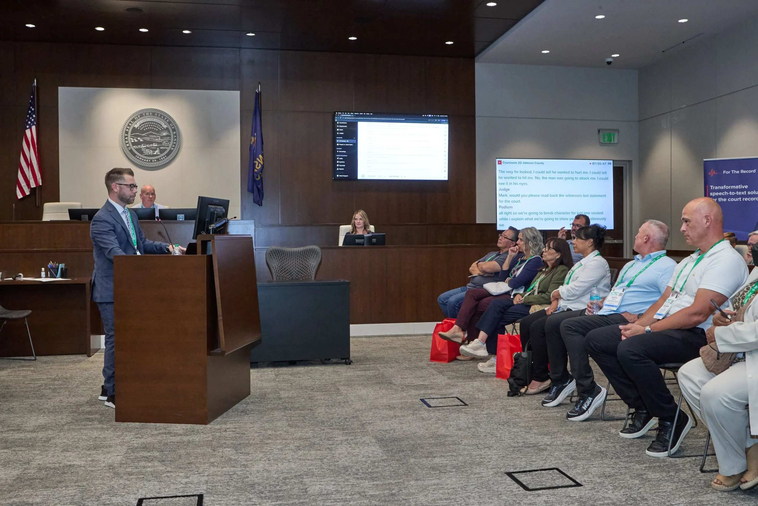 People in a courtroom watching a demonstration