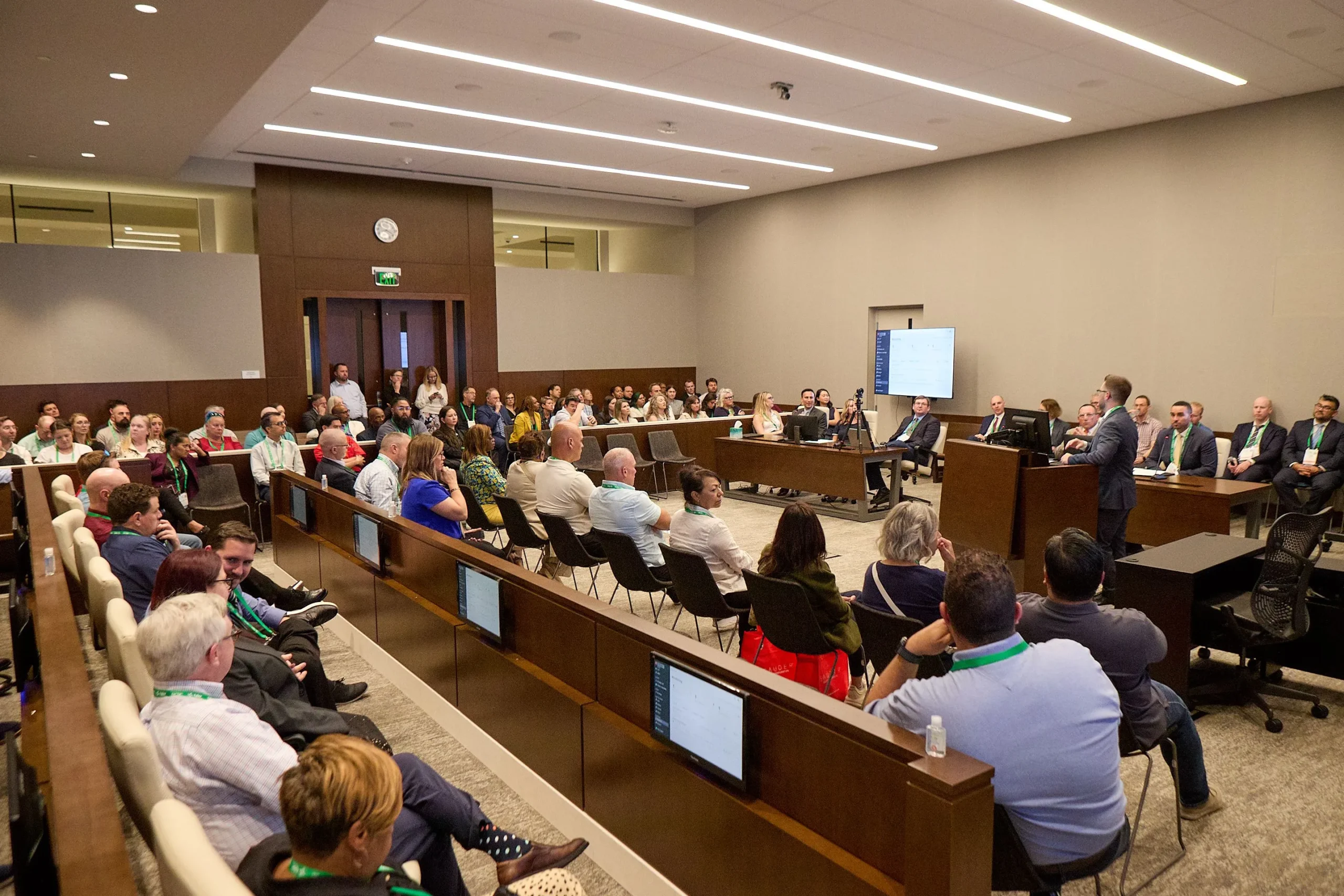 A group of people listening to a demonstration in a courtroom
