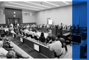 A courtroom filled with people listening to a technology demonstration